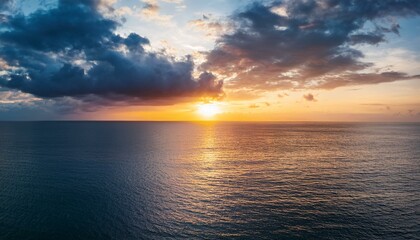 Obraz premium dramatic sunset and cloudy sky sea calm sea with cloudy sky through the clouds over sunset ocean and cloudy sky background tranquil seascape horizon over the sunset sea water calm cloudy sky