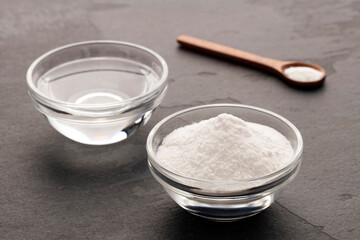 Baking soda powder in a spoon and bowl with vinegar - Healthy food.