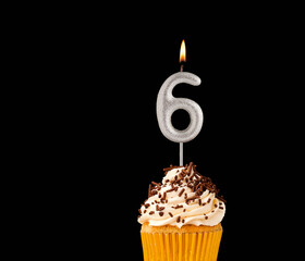 Birthday cupcake on black background - Number 6 shaped candles.