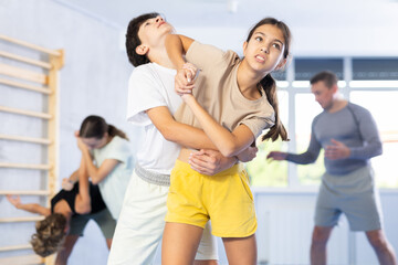 Fototapeta premium Preteen children pairs learning strength self-defense in the gym