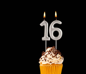 Birthday cupcake on black background - Number 16 shaped candles.