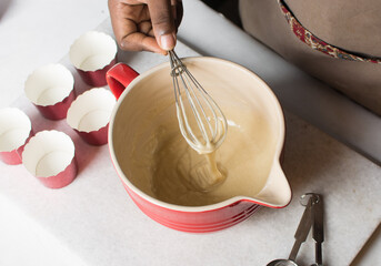 Whisking Vanilla cupcake batter in a mixing bowl, process of making cupcakes 