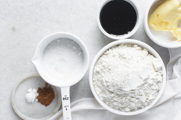 mise en place of ingredients for making molasses cookies, top view of sugar, butter, flour molasses on a marble table, process of making molasses spice cookies