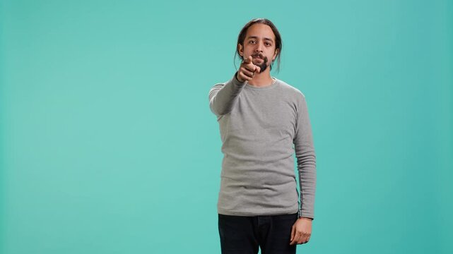 Angry man fighting with friend over debacle, putting blame on him, isolated over studio background. Rude person in disagreement with mate, swearing and pointing finger, camera A