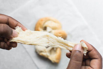 overhead view of bread being pulled apart, top view of bread with good gluten development being...