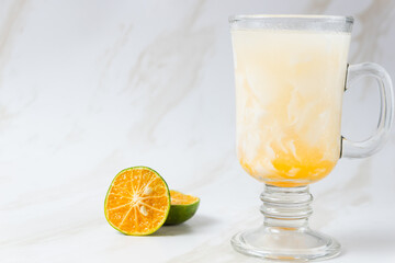 Es Kelapa Jeruk, a typical Indonesian drink made from fresh oranges squeezed with grated young coconut. with copy space. perfect for recipe, article, catalogue, or any commercial purposes.