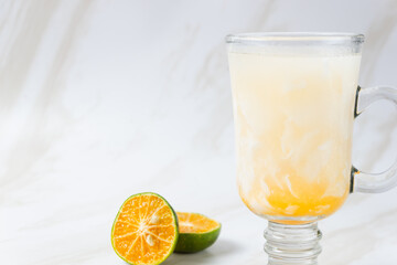 Es Kelapa Jeruk, a typical Indonesian drink made from fresh oranges squeezed with grated young coconut. with copy space. perfect for recipe, article, catalogue, or any commercial purposes.