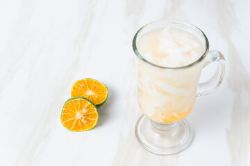 Es Kelapa Jeruk, a typical Indonesian drink made from fresh oranges squeezed with grated young coconut. with copy space. perfect for recipe, article, catalogue, or any commercial purposes.