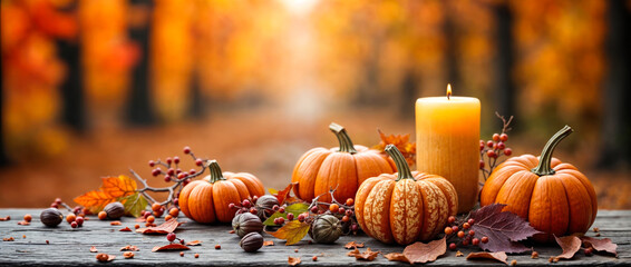 Autumn background with pumpkins, burning candle and colorful leaves on rustic wood in front of forest