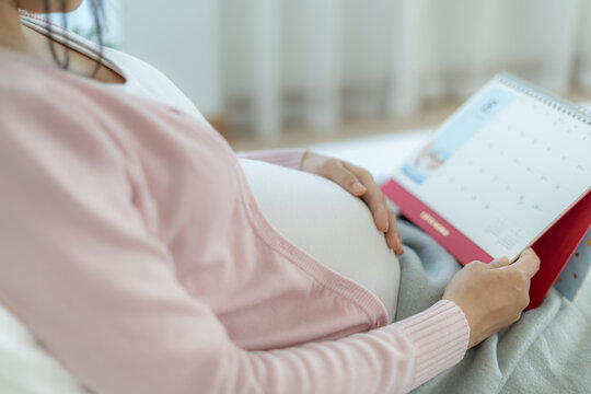 pregnant woman look schedule for due date of birth. Caesarean section is a way for pregnant to know a due date. prepare, newborn, developmental, monitor, appointment, maternity leave, gestational age.