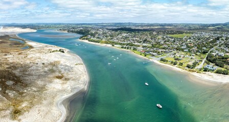 Boats mooored, township and the giant sandspit in the Mangawhai Harbour, Mangawhai, Northland, New Zealand.