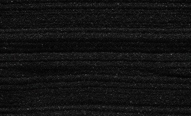 Dark black sand. Stripes and ripples of smooth volcanic sand texture or wallpaper. Wave pattern in black sand background.