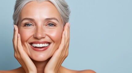 Radiant beauty of mature woman with silver hair on light blue background