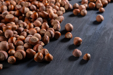 Raw hazelnuts in a stone mortar against a dark background