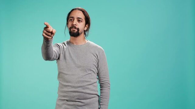 Angry man fighting with friend over debacle, putting blame on him, isolated over studio background. Rude person in disagreement with mate, swearing and pointing finger, camera B