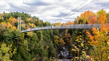 Coaticook, Canada - Oct. 12 2024: Suspension Bridge in Colorful autumn season in Parc de la Gorge