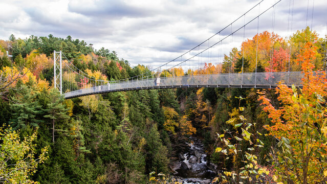 Coaticook, Canada - Oct. 12 2024: Suspension Bridge in Colorful autumn season in Parc de la Gorge