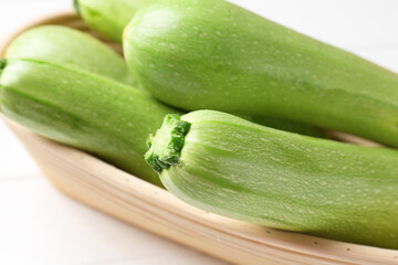 Fresh ripe zucchinis on white table, closeup