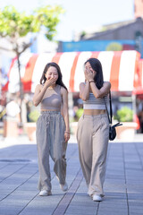 Two Taiwanese women in their 30s wearing casual outfits walk along Dihua Street in Taipei City, Taiwan, in September.