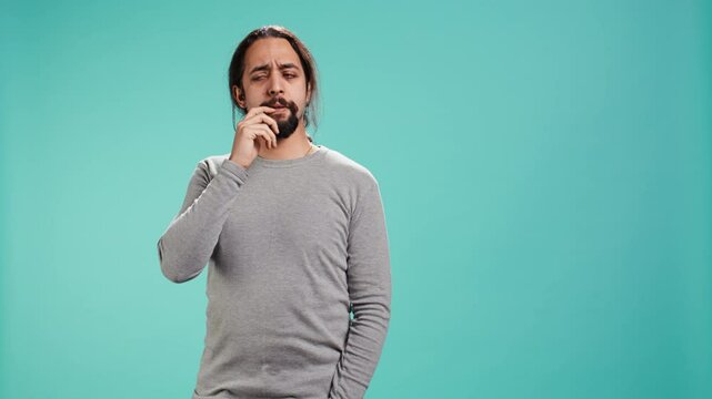 Portrait of man feeling perplexed by confusing information, isolated over studio background. Person scratching head, looking around with puzzled facial expression, camera B