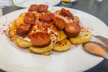 Morcilla patatera served over fried eggs and potatoes