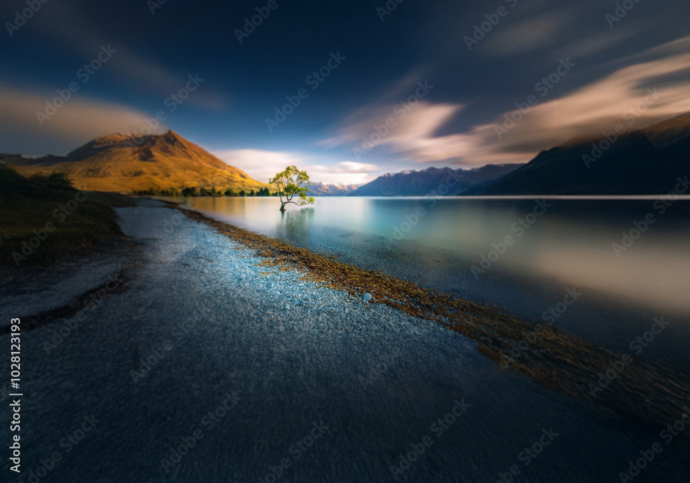 Poster a lone tree stands in a calm lake, surrounded by mountains. the water is a soft blue and the sky is 