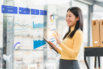 young woman in yellow sweater is analyzing business data on digital screen, showcasing graphs and statistics. She appears engaged and focused, using tablet to interact with information