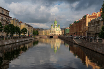 View of Saint Isidore's (Isidorovskaya) Church against the background of the Mogilev Bridge over the Griboyedov Canal on a sunny summer day, St. Petersburg, Russia