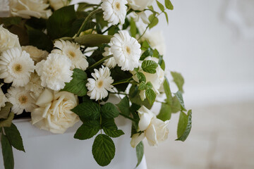 A bouquet of white roses and daisies. The roses are the main focus of the image, with their white petals and green stems. The daisies are smaller and more spread out