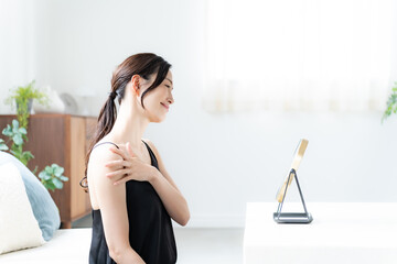 デコルテを触るワンピースを着た女性