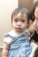 A 1 year old Taiwanese girl spending time with her parents, a man and woman in their 20s, near the entrance of a high rise apartment in Taichung City, Taiwan.