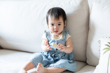 A 1 year old Taiwanese girl spending time playing happily with her parents, a man and woman in their 20s, in a room of a high rise apartment in Taichung City, Taiwan.