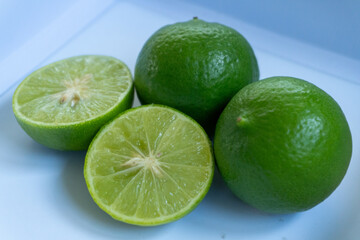 jeruk nipis or Lime green with cut in half and slices isolated on white background.