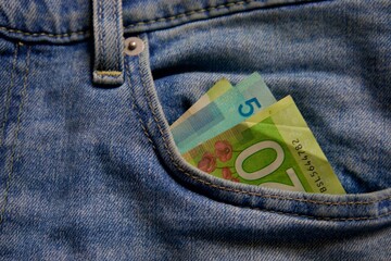 banknotes in the pocket of blue jeans