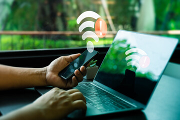 Person Holding Smartphone and Laptop with Wi-Fi Connection Error Warning in Modern Workplace....