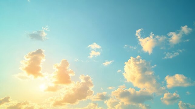 2408 53.A serene summer morning sky, with a mix of white and yellow clouds glowing in the soft light of the rising sun. The clear blue sky serves as a backdrop, while the clouds catch the golden