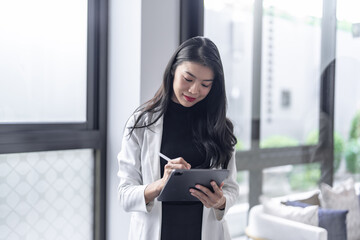 Beautiful asian doctor Education profession doctor in white uniform gown coat Professional medical doctor with tablet at seminar or hospital wellness center