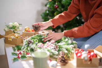 Woman making mistletoe wreath Christmas wreath decoration with hand made DIY winter greenery florist hands making Christmas wreath beautiful mistletoe.