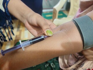 Medical technologist doing blood draw services for patient. Pathologist or lab assistant with sterile  taking blood sample from patient. India