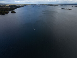 Aerial view of small islands dotting the calm waters of the Thousand Islands region, showcasing the scenic landscape and natural beauty of the Canadian side.