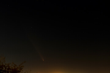 The periodic comet Tsuchinshan Atlas 2023 A3, faintly glowing as it crosses the night sky, captured...