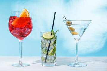 A variety of cocktails arranged on a table against a light blue background