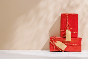 Christmas template featuring gift boxes on a table with shadows and sun glares softly falling on...