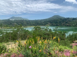 Serene Lake and Mountains in Manado. A picturesque view of a serene lake nestled between lush mountains.