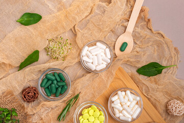 Homeopathy and alternative medicine. Meds, pills, capsules, supplements in small bowls on a wooden desk from above in rustic style. Top view homeopathic meds, flat lay still life.