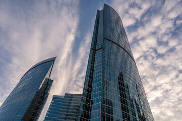 Angled view of modern skyscrapers in business district against blue sky. Looking Up high-rise office buildings.