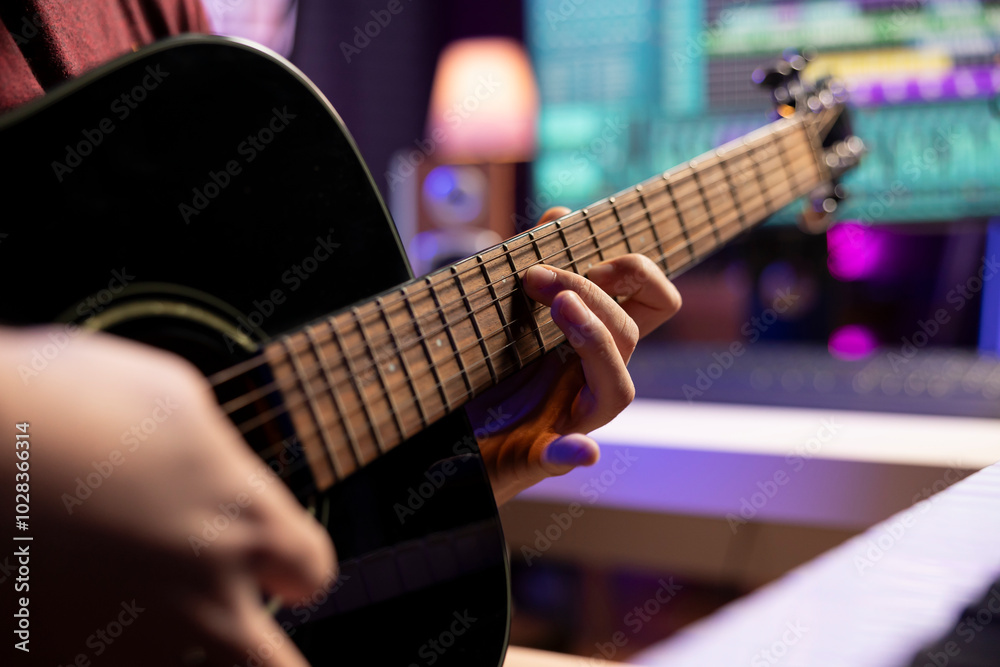 Poster music producer playing a new song on his acoustic guitar before recording new tunes, mixing and mast