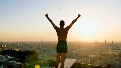 Triumphant runner celebrating at sunrise overlooking paris cityscape