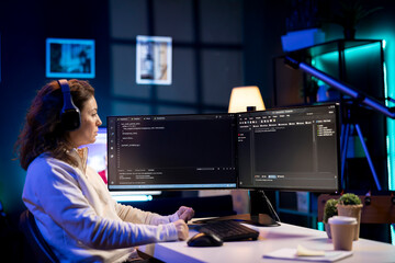 Woman listening music while doing software quality assurance, reading source code on computer...