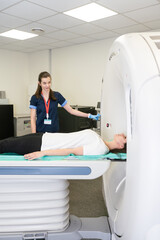 Radiologist with a female patient in the room of computed tomography.